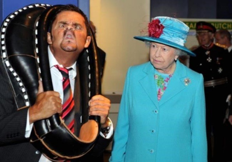 La reina Isabel II observa a Tommy Mattinson, campeón mundial de muecas, durante su visita al Museo Breacon de Whitehaven, Cumbria