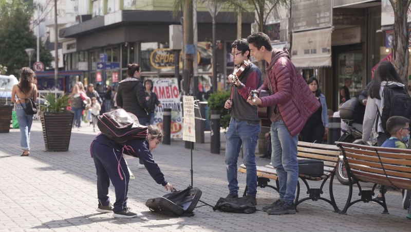 Una nena corre a dejarles dinero después de escucharlos junto a su mamá.