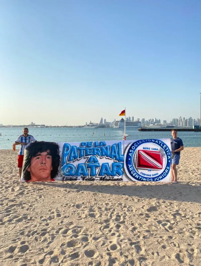  La bandera con la cara de Maradona que llevaron tres argentinos a Qatar. 