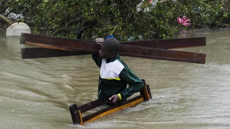  Un hombre lleva las partes de una cama en medio de la inundación por las calles de Quelimane, Mozambique (EFE/EPA/ANDRE CATUEIRA)