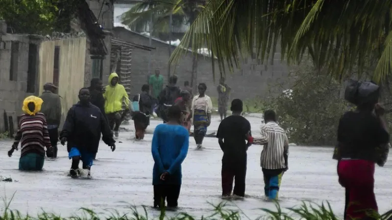  Una acera anegada en Quelimane no impide que la gente se aventure a atravesarla en busca de víveres y otros elementos de necesidad básica en esta ciudad de Mozambique (EFE/EPA/ANDRE CATUEIRA)