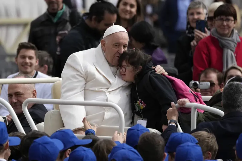 El papa Francisco abraza a una niña al finalizar su audiencia general semanal en la Plaza de San Pedro, Vaticano, miércoles 29 de marzo de 2023.