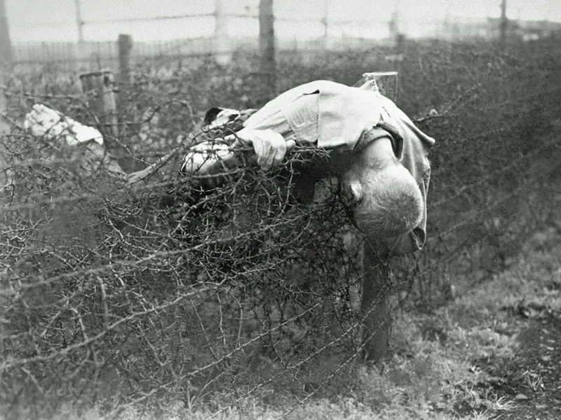  El cuerpo de un prisionero adolescente sobre los alambres de púas que rodeaban el campo de exterminio nazi