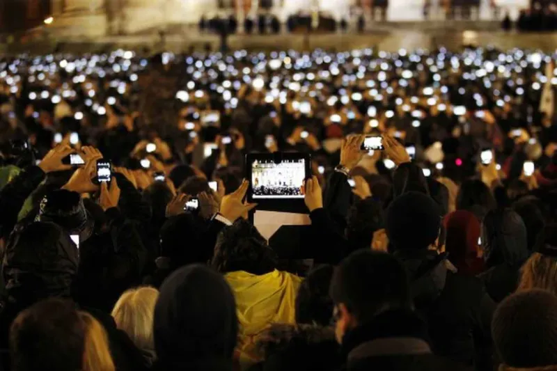 Feligreses fotografian con sus teléfonos y tabletas un discurso del papa Francisco