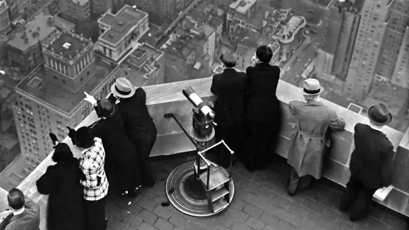 Un grupo de personas contemplan la ciudad de Nueva York desde el mirador del Empire State, que para 1940 era el edificio más alto del condado 