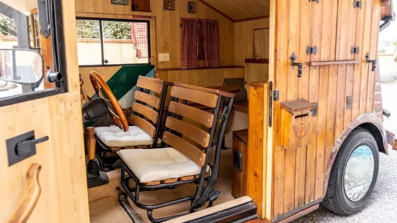 Dos butacas de madera con almohadones y las plazas posteriores, que representan más una casa que un auto