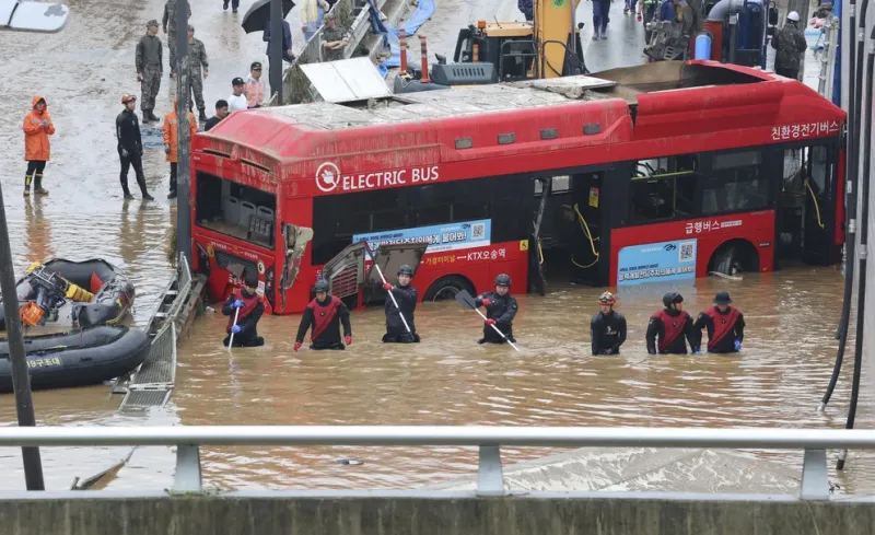  Rescatistas buscan sobrevivientes a lo largo de un camino sumergido por las aguas que conducen a un túnel subterráneo en Cheongju, Corea del Sur, este domingo 16 de julio de 2023. Días de fuertes lluvias provocaron inundaciones repentinas y deslizamiento