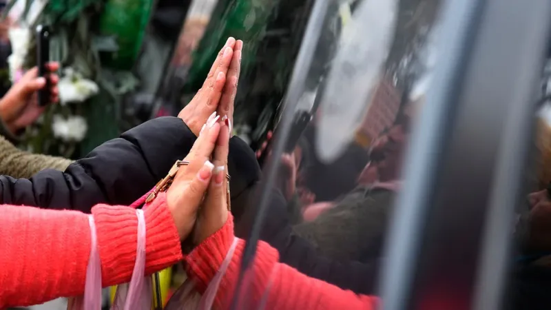 Las manos de los vecinos en el coche fúnebre (Maximiliano Luna)