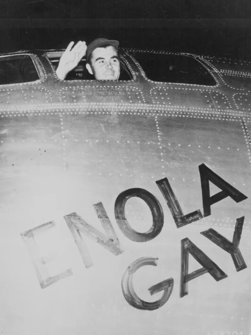  El coronel Paul Tibbets, piloto del Enola Gay, el avión que lanzó la bomba atómica sobre Hiroshima, saluda desde su cabina antes de despegar de Tinian el 6 de agosto de 1945 (Administración Nacional de Archivos y Registros de EE. UU./ REUTERS)