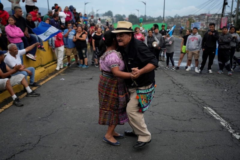 12/31Una pareja baila en la calle durante un paro nacional en la Ciudad de Guatemala, mientras la gente protesta para apoyar al presidente electo Bernardo Arévalo después de que el tribunal más alto de Guatemala confirmó una medida de los fiscales para su