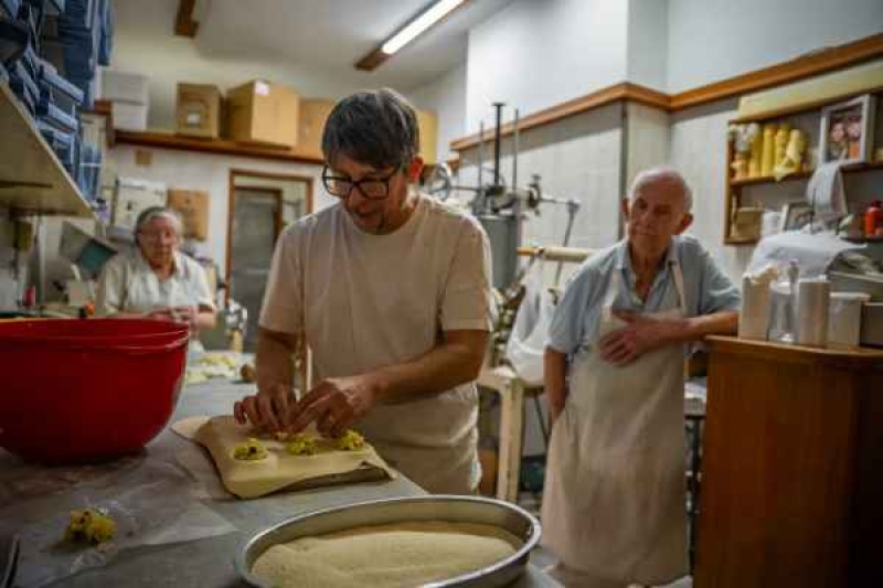 Julio observa a su hijo Luis mientras rellena los sorrentinos con muzzarella, jamón y perejil (Foto: Nicolás González).