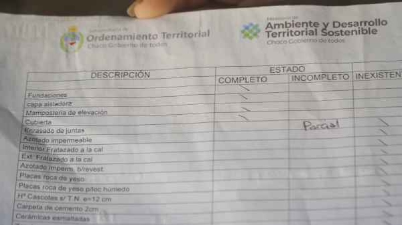 Daiana muestra el papel que le entregó el Gobierno de Chaco. Allí se destacan todos los faltantes de su vivienda. Foto: Telenoche.