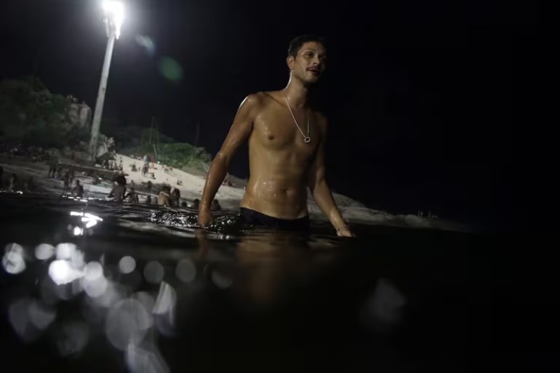  En la playa Arpoador, aún después de la puesta de Sol hubo gente en el agua (REUTERS/Pilar Olivares)