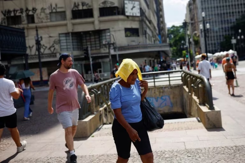  Una mujer camina por San Pablo en medio de la ola de calor que alcanzó los 34 grados este domingo (REUTERS/Amanda Perobelli)